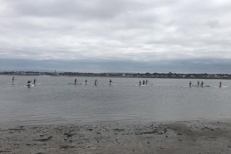 E&H women's basketball paddleboarding in a lagoon.